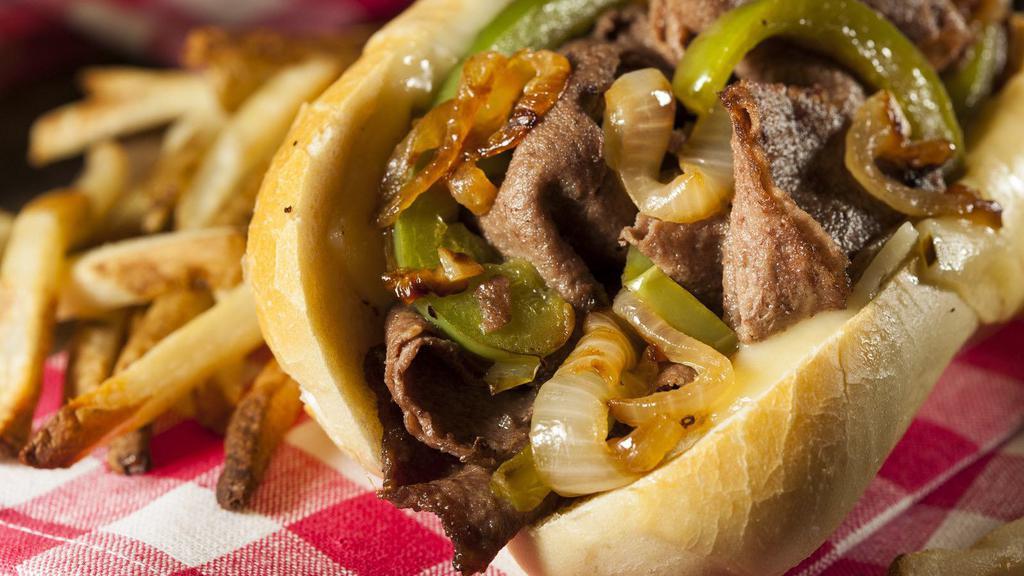 Philly Cheesesteak · The perfect Philly cheesesteak with green pepper, artfully sautéed onions, and fresh lettuce and tomato.