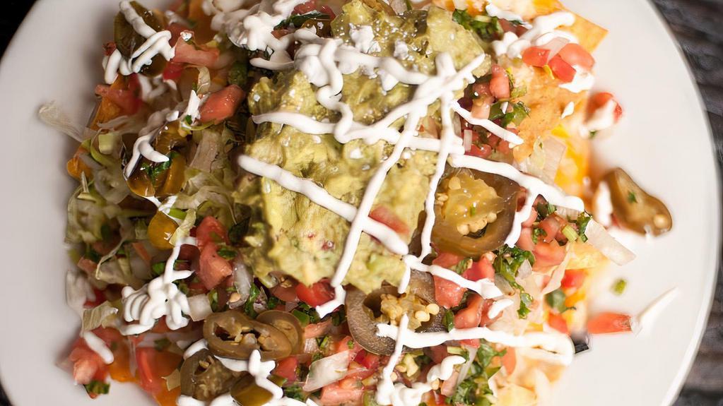 Nachos · Gluten free. Fresh tortilla chips topped with Monterey Jack cheese, Cheddar cheese, lettuce, black beans, guacamole, jalapeños & sour cream. Add a choice of  chicken or beef for an additional charge.