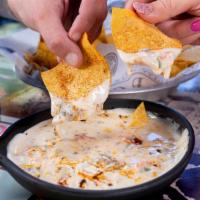 Loaded Queso · Queso blanco, taco-seasoned beef, pico; with tortilla chips