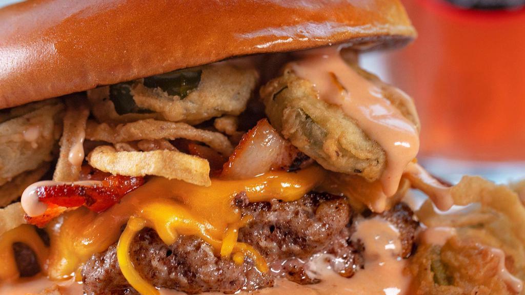 The Old Town Road · Half-pound beef patty, yellow cheddar, bacon, hand-breaded fried jalapenos & onions, BBQ aioli, brioche bun and a whole fried jalapeno