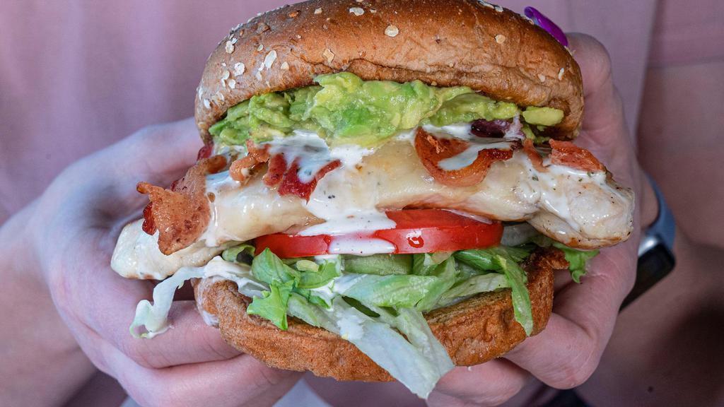 Chicken Bacon Club · Grilled chicken breast topped with bacon, cheddar, lettuce, tomato, smashed avocado, and ranch dressing on a wheat bun
