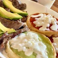 Sopes · Three round hand made corn thick tortillas topped with green and red salsas, onions, sour cr...
