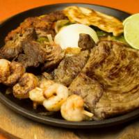 Parrillada · Grilled shrimp, chicken, ribeye steak, pork ribs, sausage and chorizo on a bed of grilled on...