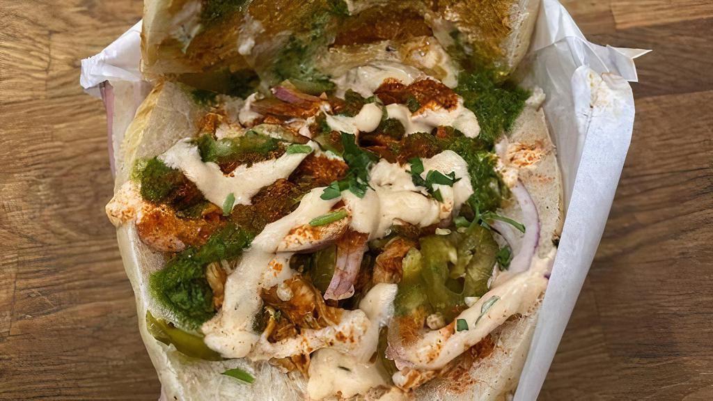 Fire Dancer · Pita, spicy harissa chicken, spicy baba, feta and pepper spread, red onions, chili spread, house-pickled jalapenos, spicy yogurt, zhugg, and berber seasoning.