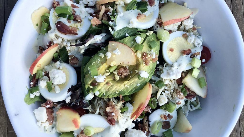 Cobb Salad  · Mixed greens and spinach, honey mustard chicken, hard boiled egg, bacon bits, cherry tomatoes, roasted pumpkin seeds, blue cheese, green onions & sliced avocado - topped with avocado ranch dressing