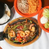 Fajitas · Steak or chicken with grilled onions, tomatoes, green peppers. Guacamole, cheese, lettuce, s...