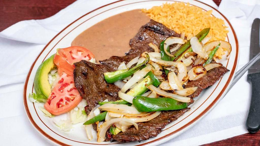 Carne Asada Al Carbon · Skirt steak cooked on the grill with onions and jalapeno peppers. Served with refried beans, rice and salad.