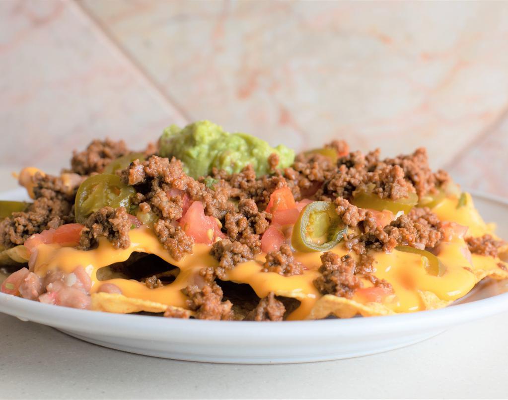 Nachos · A bed of tortilla chips, Beans, nacho cheese, jalapeños, pico de gallo, guacamole and your choice of meat.
