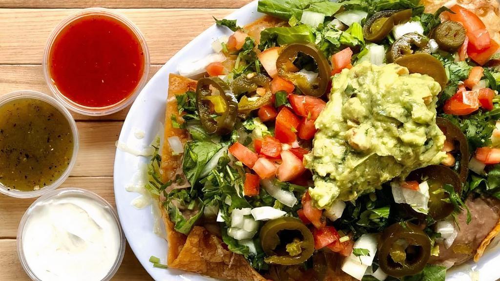 Nachos, Nachos, Nachos · Housemade tortilla chips smothered in Chihuahua cheese, guacamole, refried beans, diced tomato and onion, fresh cilantro, pickled jalapeños, lettuce, and sour cream.