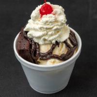 Single Scoop Brownie Sundae · Fudge brownie topped with a scoop of vanilla ice cream, hot fudge and finished with homemade...