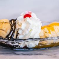 Twin Treat · Two sundaes in one dish!  Two scoops of vanilla ice cream with hot fudge on one and buttersc...