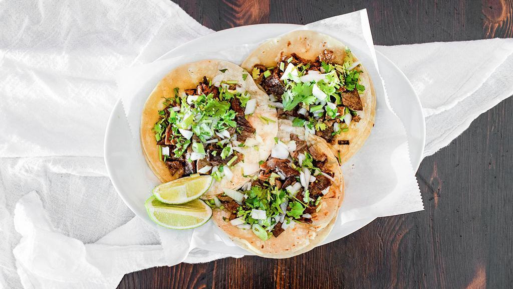Tacos De Carnitas · Tender Pork Marinated in garlic. fresh lime, orange juices and spices. slow Rosted and served on a flour tortilla topped with onions, cilantro and quest fresco, and drizzle of spicy house hot sauce, Served with a side of beans.