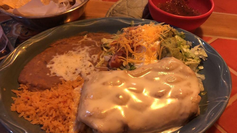 Chimichanga · A stuffed flour tortilla with shredded chicken beef tips or shrimp deep-fried and topped with cheese sauce. served with rice beans lettuce sour cream and pico de gallo.