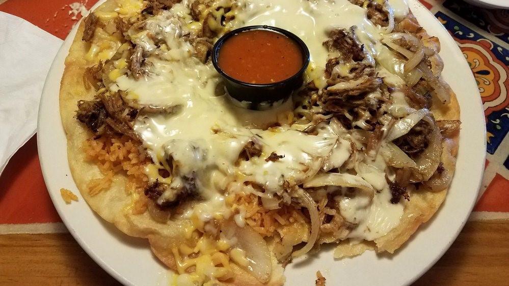 Sombrero · Marinated pork cooked on the grill with onions and mushrooms. Topped with cheese and rice and placed in a fried ﬂour sombrero. Served with a side of hot sauce and tortillas.