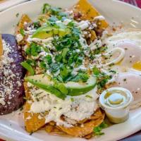 Chilaquiles · Corn chips cooked in jalapeño sauce topped with chicken, avocado, sour cream, feta and cilan...