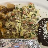 Machaca · Two eggs scrambled with lean shredded beef, onions, tomatoes and jalapeno. Served with refri...