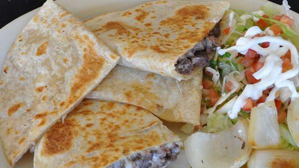 Fiesta Quesadillas · A large flour tortilla with melted cheese, chicken, chorizo and onions. Served with lettuce, tomatoes, sour cream, guacamole and rice.