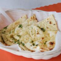 Garlic Naan · White flour dough mixed with milk and butter, baked in a tandoor clay oven.