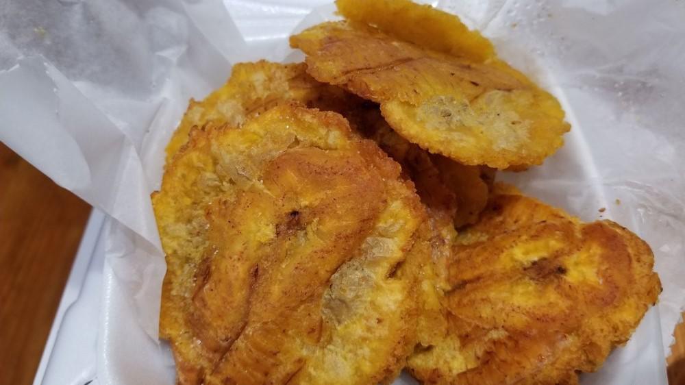 Tostones · Lightly fried and salted slices of plantain drizzled with garlic oil.