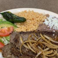 #2. Bistec  Encebollado · Thin steak topped with grilled onions . Served with rice, beans and tortillas.