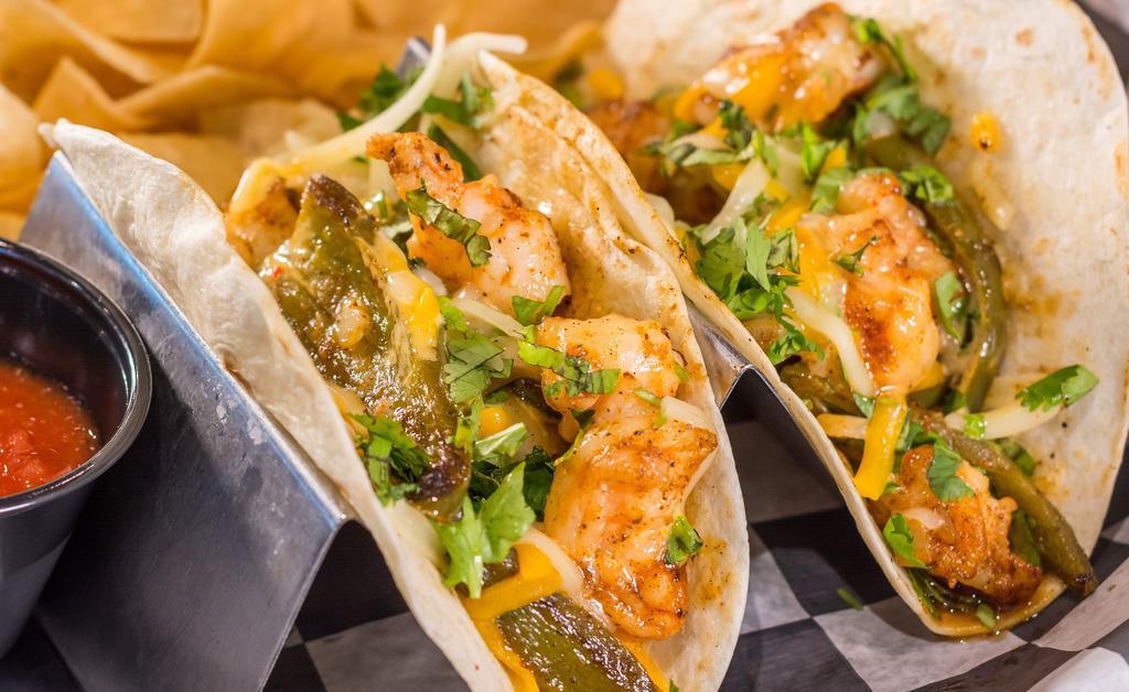 Blackened Shrimp Taco · Flour tortillas, grilled shrimp, diced onion, cheddar jack cheese, jalapeños, house dressing, and cilantro. Served with chips and salsa.