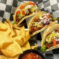 Veggin' Out Tacos · Corn Tortillas, 100% Plant-Based Taco Meat, Pinto Beans, Guacamole, Tomato, Lettuce, Red Oni...