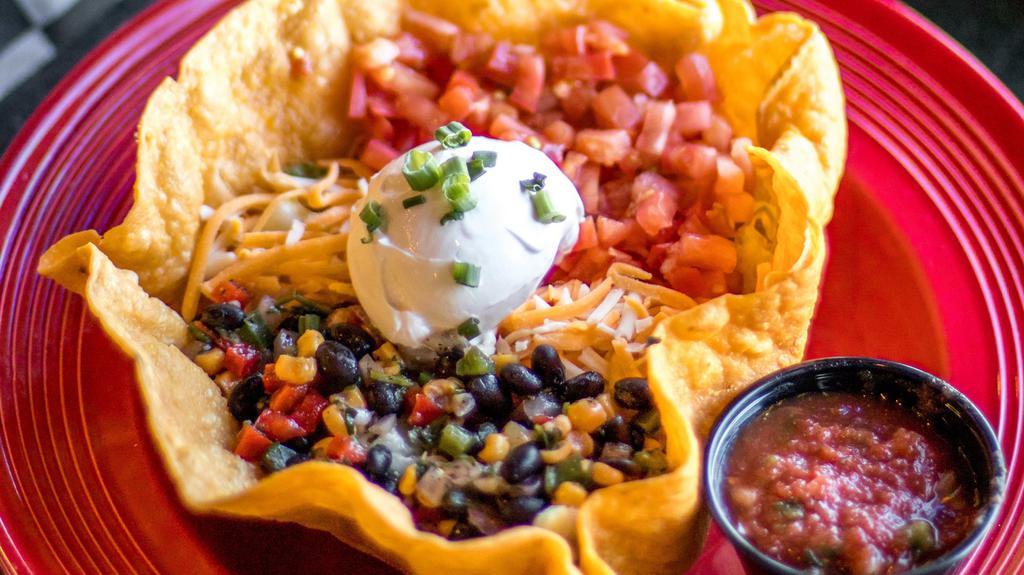 Taco Salad · Shredded chicken or ground beef, pinto beans, cheddar Jack cheese, tomatoes, black bean salsa, mixed greens, sour cream, and homemade salsa.