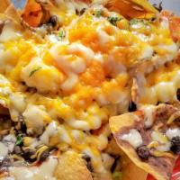 Black Bean Nachos · Fresh tortilla chips topped with black beans, smoked chile sauce, Jack and Cheddar cheese an...