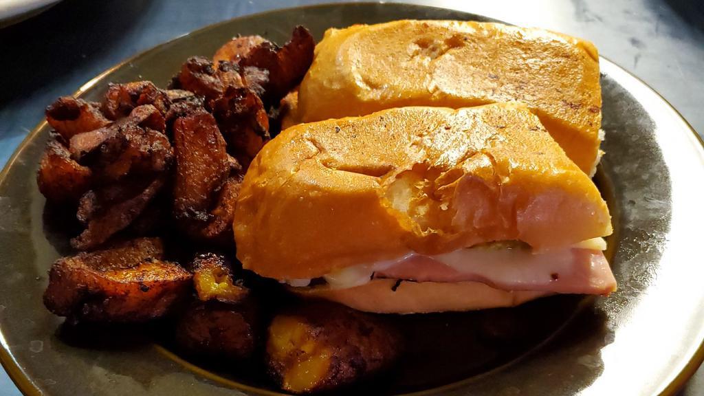 Cuban Sandwich (Media Noche) · Marinated pork, ham, Swiss cheese, mustard, pickles on a hoagie roll. Served with plantains.