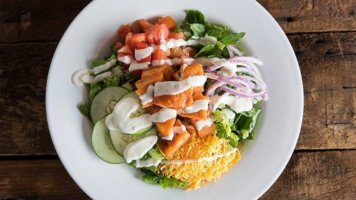Buffalo Chicken · Crisp romaine, tomatoes, cucumbers, Cheddar, red onion, buffalo tenders, and ranch dressing.