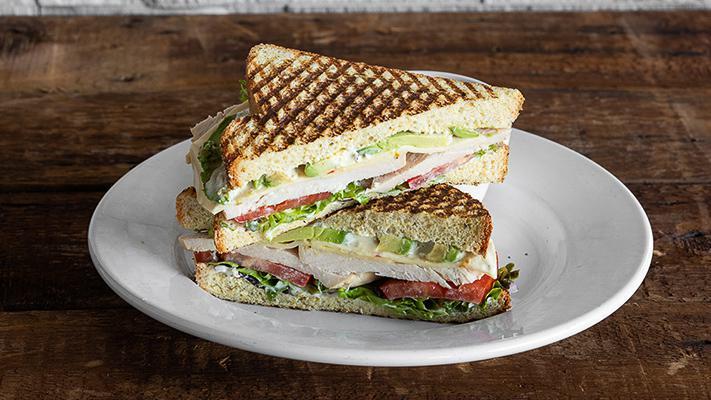Turkey Jalapeño Ranch Panini · Roasted turkey carved to order, jalapeño ranch, Pepper Jack, avocado, field greens, tomatoes, and red onions on jalapeño Cheddar bread. Served with your choice of side.