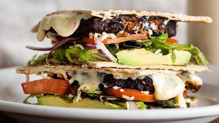 Chipotle Black Bean Burger · Wheat flatbread, chipotle black bean burger, Pepper Jack cheese, field greens, red onion, tomatoes, avocado, and chipotle ranch.