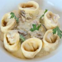 Tortelloni Alla Papalina · Home-made pasta filled with ricotta, sauteéd in olive oil, onions, pancetta, mushrooms, and ...