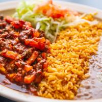 Guisado De Puerco · Stewed Pork served with Rice and Beans.