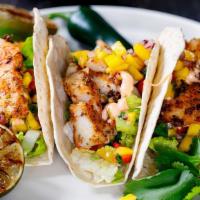 Fish Tacos · Three grilled fish tacos topped with pico de gallo.