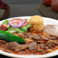 Lomo En Chile De Arbol · Rib-eye steak in a spicy red sauce served with rice, beans, and housemade tortilla.