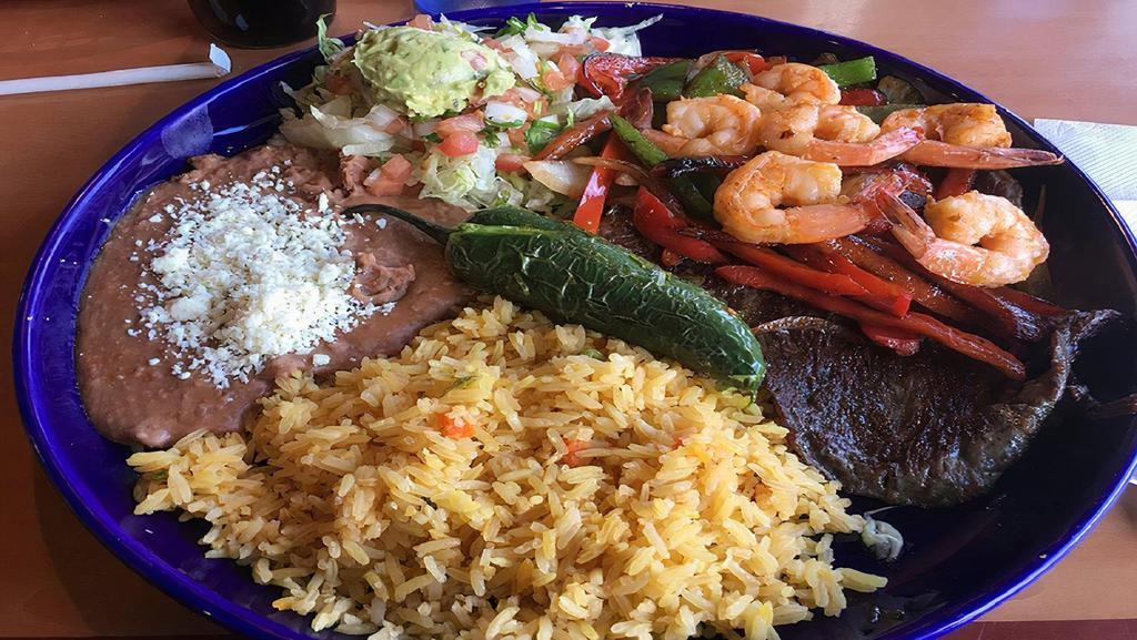 Asada Con Camarones · Tender skirt steak and grilled shrimp served with frijoles charros and panela cheese.