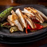 Chicken Fajitas · citrus marinated chicken breast and served with rice and beans, guacamole, roasted onions an...