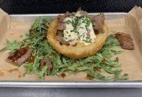 Seared Tenderloin Tips · Seasoned seared tenderloin tips served with a jumbo onion ring, and a Kolsch horseradish sau...