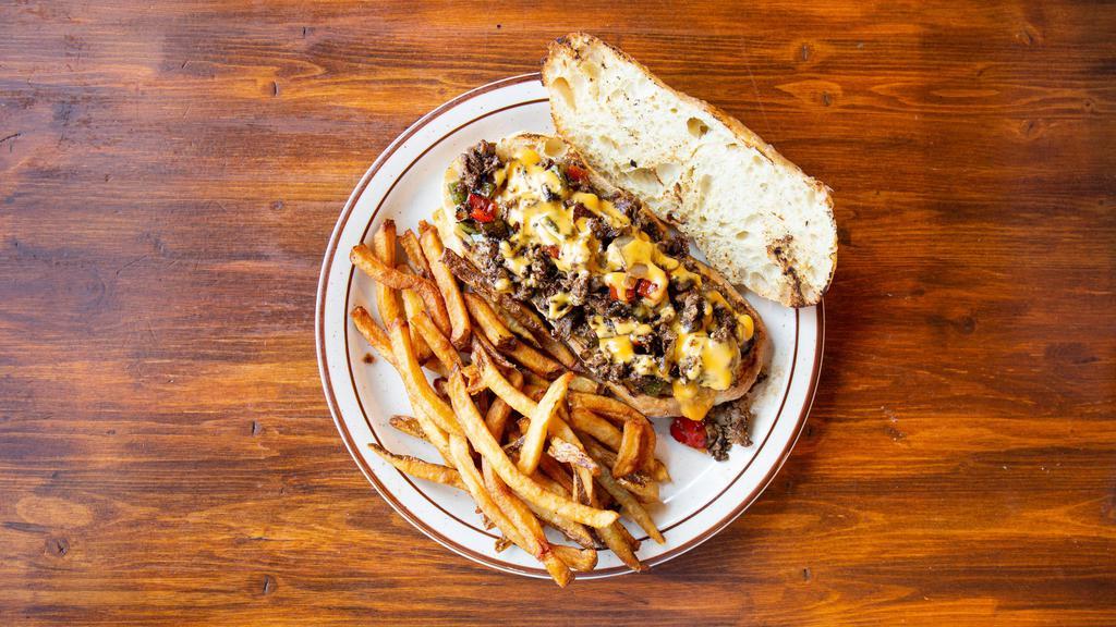 Billy'S Cheese Steak · Chopped Sirloin Steak with Green & Red Peppers, Onion, & house-made Cheese Sauce on a toasted Ciabatta Hoagie, with a side of French Fries.