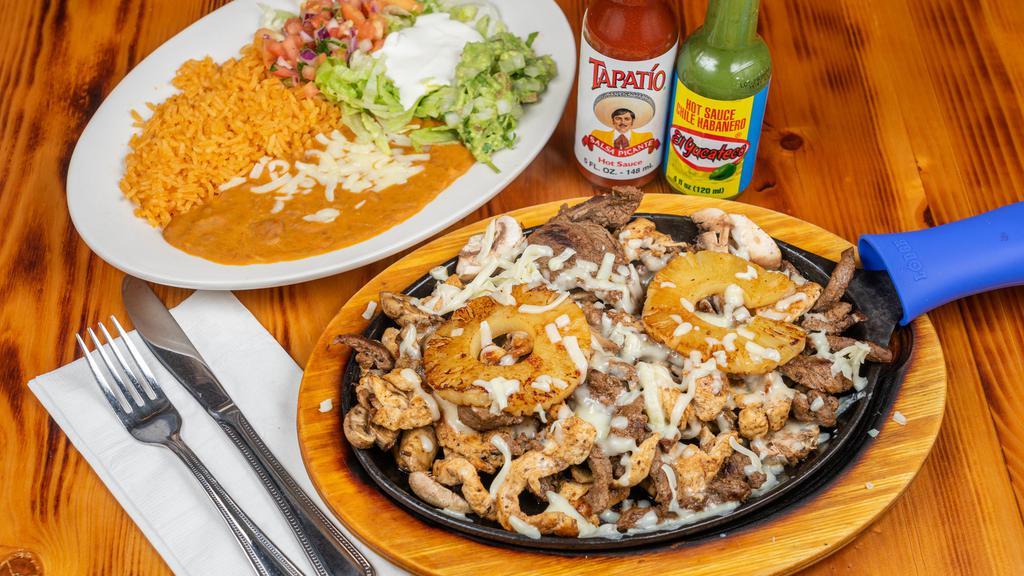Fajita Chimichanga · A jumbo flour tortilla filled with your choice of steak or grilled chicken cooked with onions, tomatoes and bell peppers, deep-fried and topped with cheese sauce. Served with rice, beans, lettuce, guacamole, sour cream and pico de gallo.