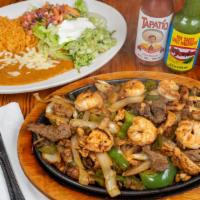Texas Fajitas · Steak, chicken and shrimp with sautéed onion, bell peppers and tomatoes. Served with lettuce...