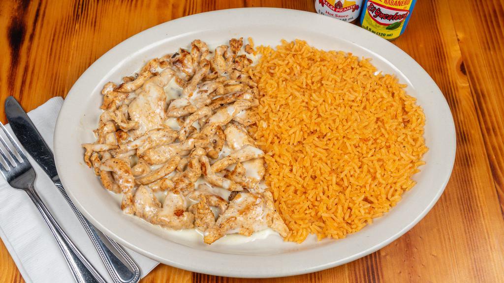 Arroz Con Pollo · Juicy grilled chicken strips covered with cheese sauce and served on a bed of rice.