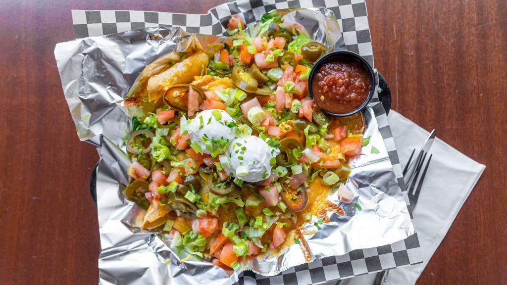 Nachos · Veggie refried beans, tomatoes, onions, jalapenos, sour cream, a blend of cheese and salsa.