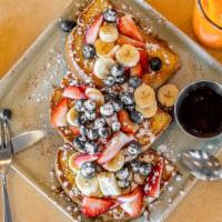 Fruity French Toast · Topped with blueberries, strawberries, bananas and cinnamon powdered sugar served with a sid...