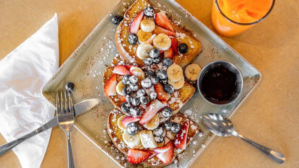 Fruity French Toast · Topped with blueberries, strawberries, bananas and cinnamon powdered sugar served with a side of our house very berry sauce.