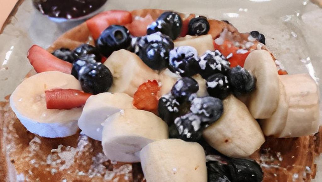 Fruity Waffle · Topped with blueberries, strawberries, bananas and cinnamon powdered sugar and served with a side of our house very berry sauce.
