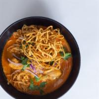 Curry Chicken Noodle (Khao Soi) · Egg noodles drenched in a creamy yellow coconut curry served with chicken thighs, green onio...