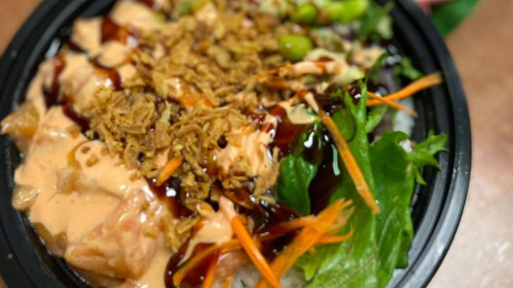 Salmon Poke Bowl (Raw) · Sushi rice,salmon (raw), mixed greens, carrot, avocado, and edamame, topped with spicy mayo and sushi sauce, and sprinkled with crispy onion and sesame seeds.