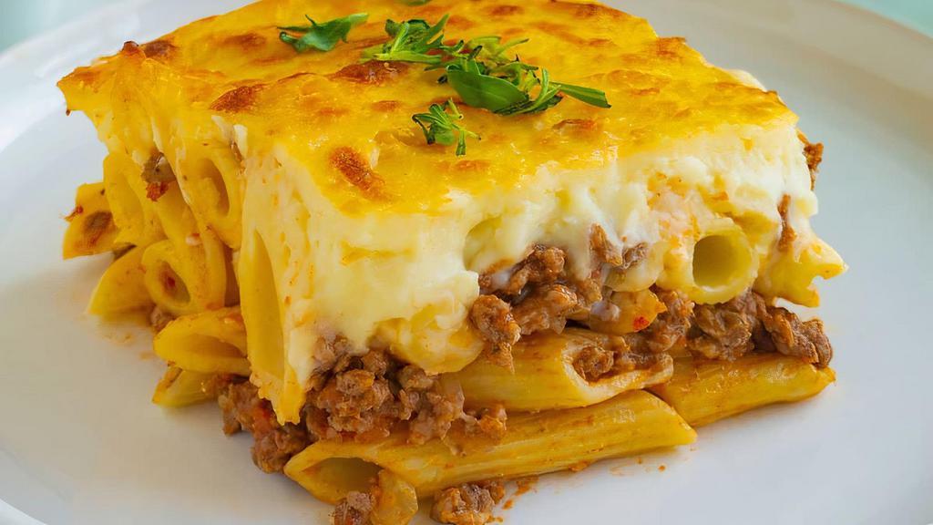 New! Macarona Bechamel · Pasta layered with a spiced beef mixture, topped with a creamy bechamel sauce and baked until golden and bubbly.
